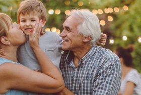 Abuelo, hija y nieto en actitud cariñosa