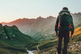 Hombre de espaldas en la cima de una montaña