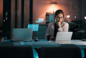 mujer trabajando con un ordenador portátil en la oficina de noche