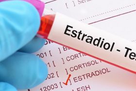 tubo de ensayo con el test de estradiol encima de tabla de valores