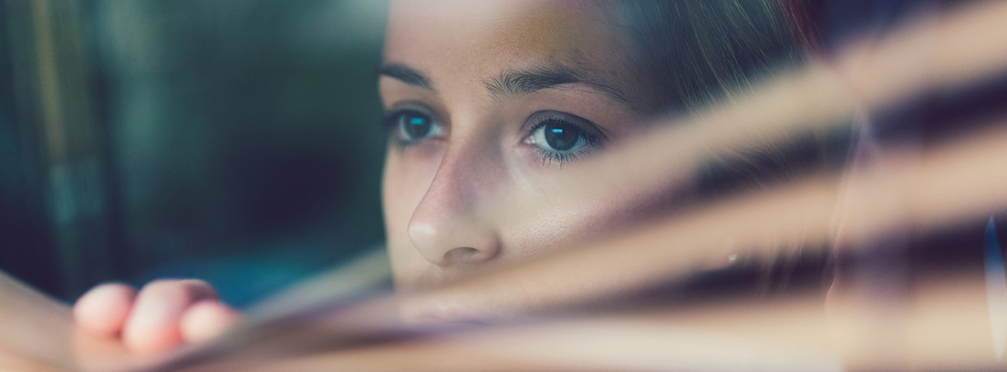 imagen de cara de mujer triste mirando por una ventana