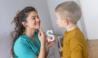 Logopeda enseñando a un niño.