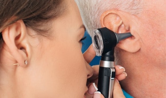 medico mirando el oído a un paciente de otitis