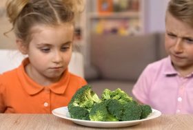 Falta de apetito en niños: niño y niña mirando un plato con brócoli