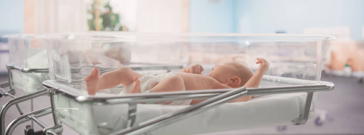 niño recién nacido c acostado en una cama de hospital en una clínica infantil