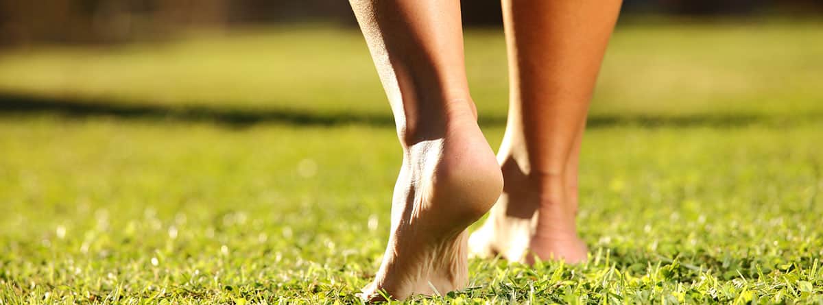 Una imagen de piernas femeninas sobre un césped en un día soleado de verano o primavera