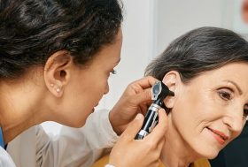 Otorrinolaringóloga examinando el oído de una mujer
