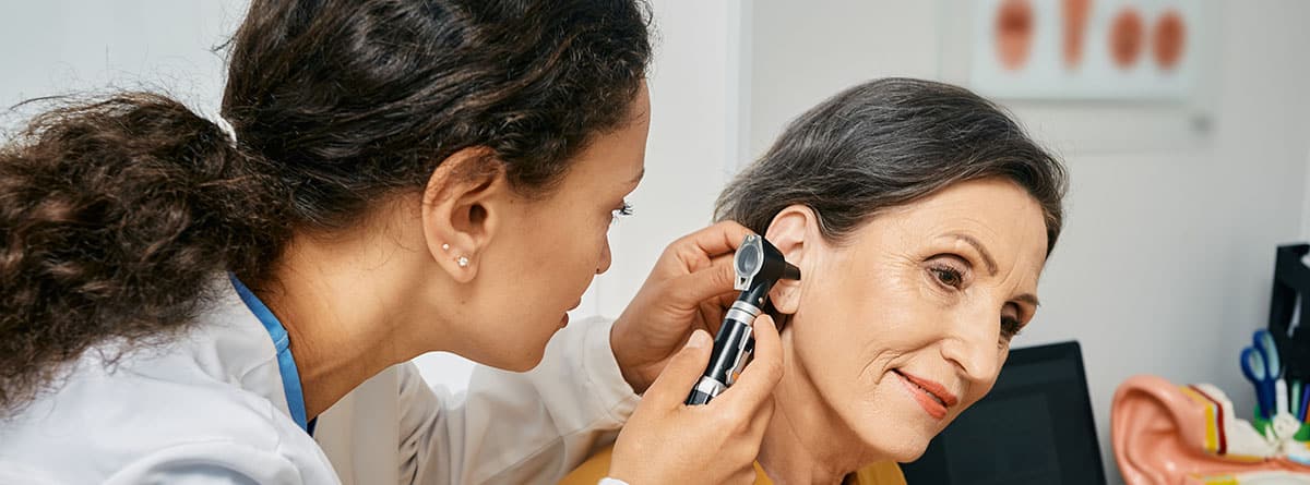 Otorrinolaringóloga examinando el oído de una mujer