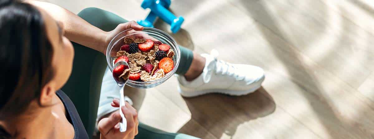 Mujer deportista comiendo un ball con alimentos ricos en fibra