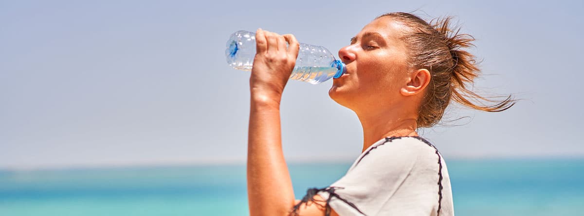 Mujer joven y deportista bebiendo de una botella de agua