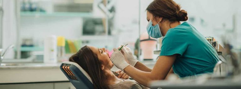 Dentista atendiendo a una mujer en su consulta