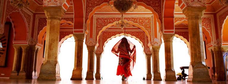 Mujer vestida con traje típico de la India, caminando en un Palacio